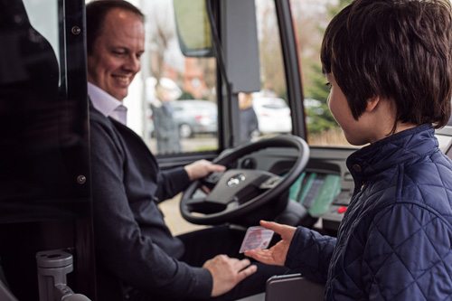 Ein Schüler zeigt einem Busfahrer sein Ticket