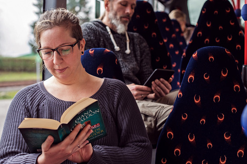 Eine Frau im Bus liest ein Buch
